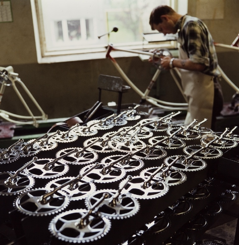 Arbeider monterer kranker på sykler i monteringsavdelingen til sykkelfabrikken til Jonas Øglænd AS i Solaveien på Sandnes.
