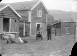 Bådstø med stabbur, bu og stall. 2 menn foran.