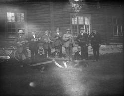 7 menn står med fele og 3 sitter på gresset med langeleik ve