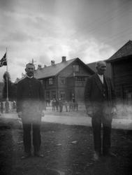 2 menn står utendørs ved Kommunehuset, Hundorp.