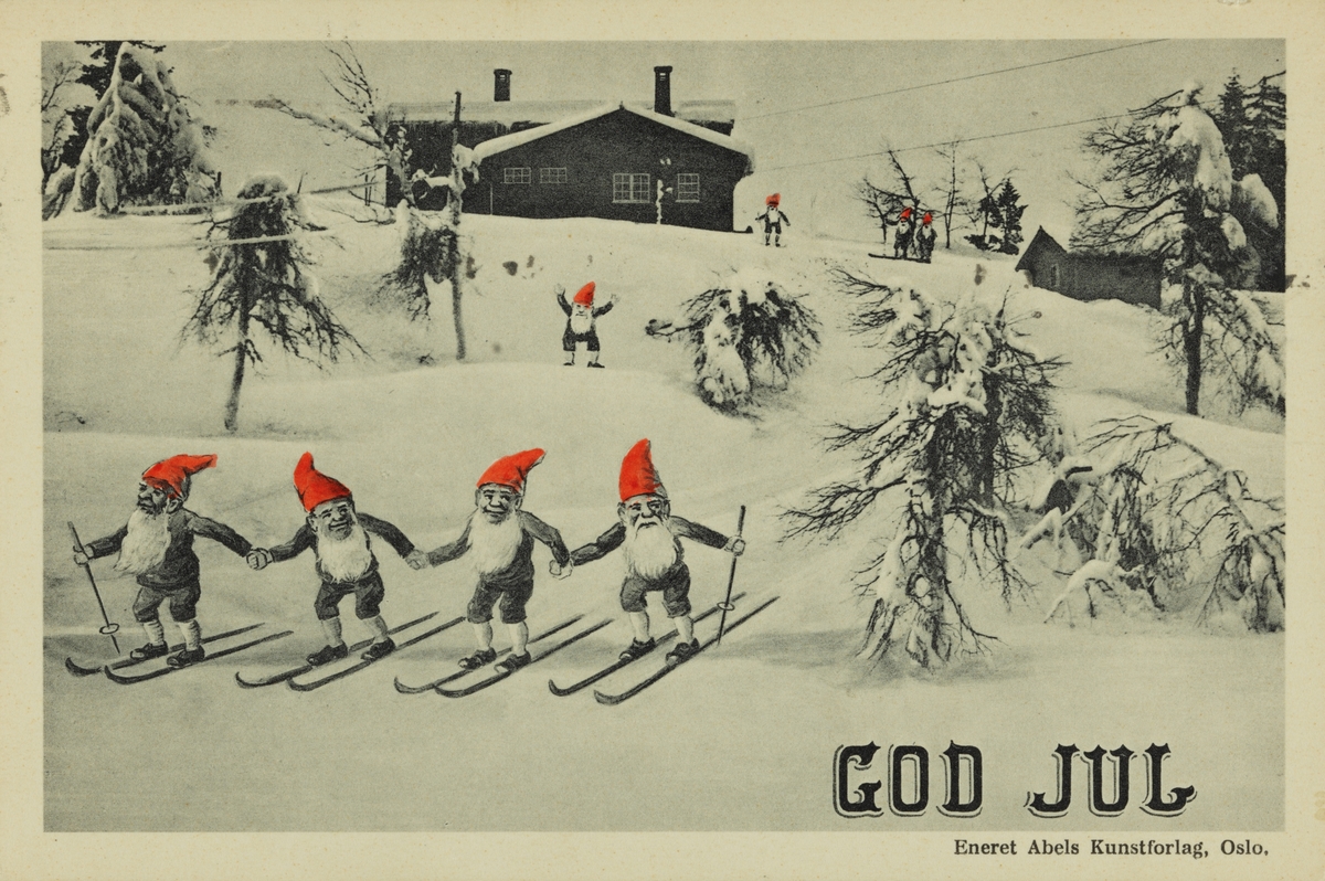 Julekort. Jule- og nyttårshilsen. Sort/hvit fotografi : Nisser med røde luer, på ski. Nissene er tegnet av Halfdan Gran. Stemplet Oslo 21.12.1931.