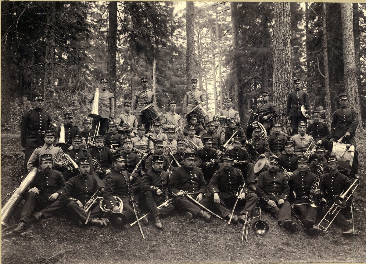 Gruppebilde av Trondheim Brigade Musikkorps i skogen (sannsynligvis Værnesskogen).
