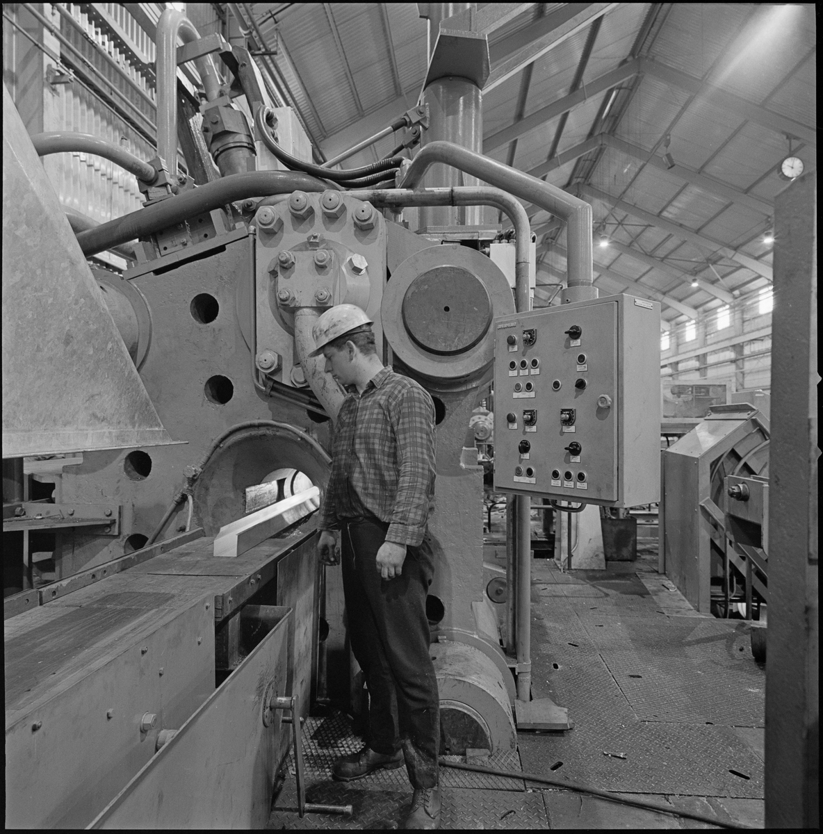 En mann følger med på et aluminiumsprodukt på et bånd på Norsk Hydro sitt aluminiumsverk på Karmøy.