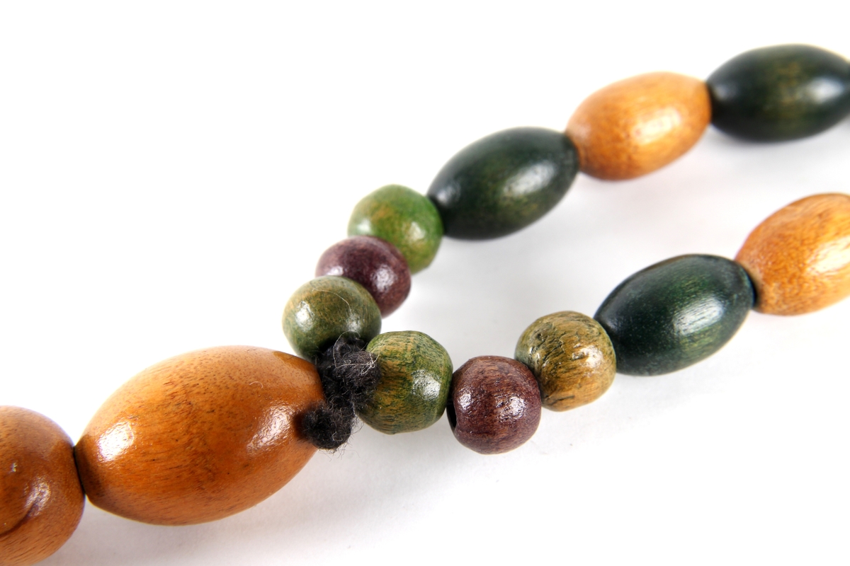 Perlekjede med runde og ovale treperler i forskjellige størrelser og farger.