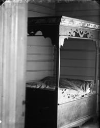 Rikard Berges fotoarkiv. Interiør, seng. Byrte, Lunde, 1907.