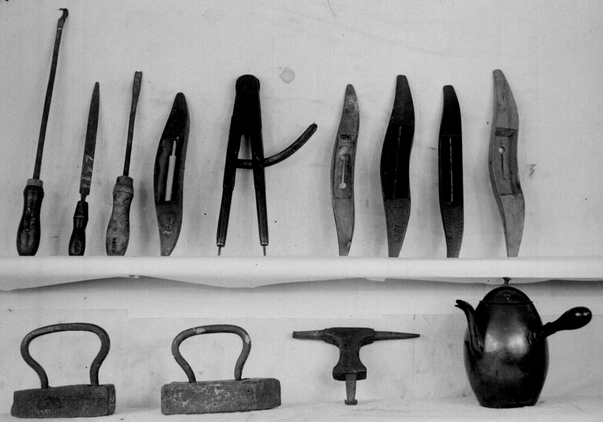 Avlang og buet vevskyttel av tre med uthuling på midten og trådspole av tre. På hver side er det skyttelen dekorert med hjerter. Den ene siden har inskripsjon MAD og den andre siden årstallet 1823