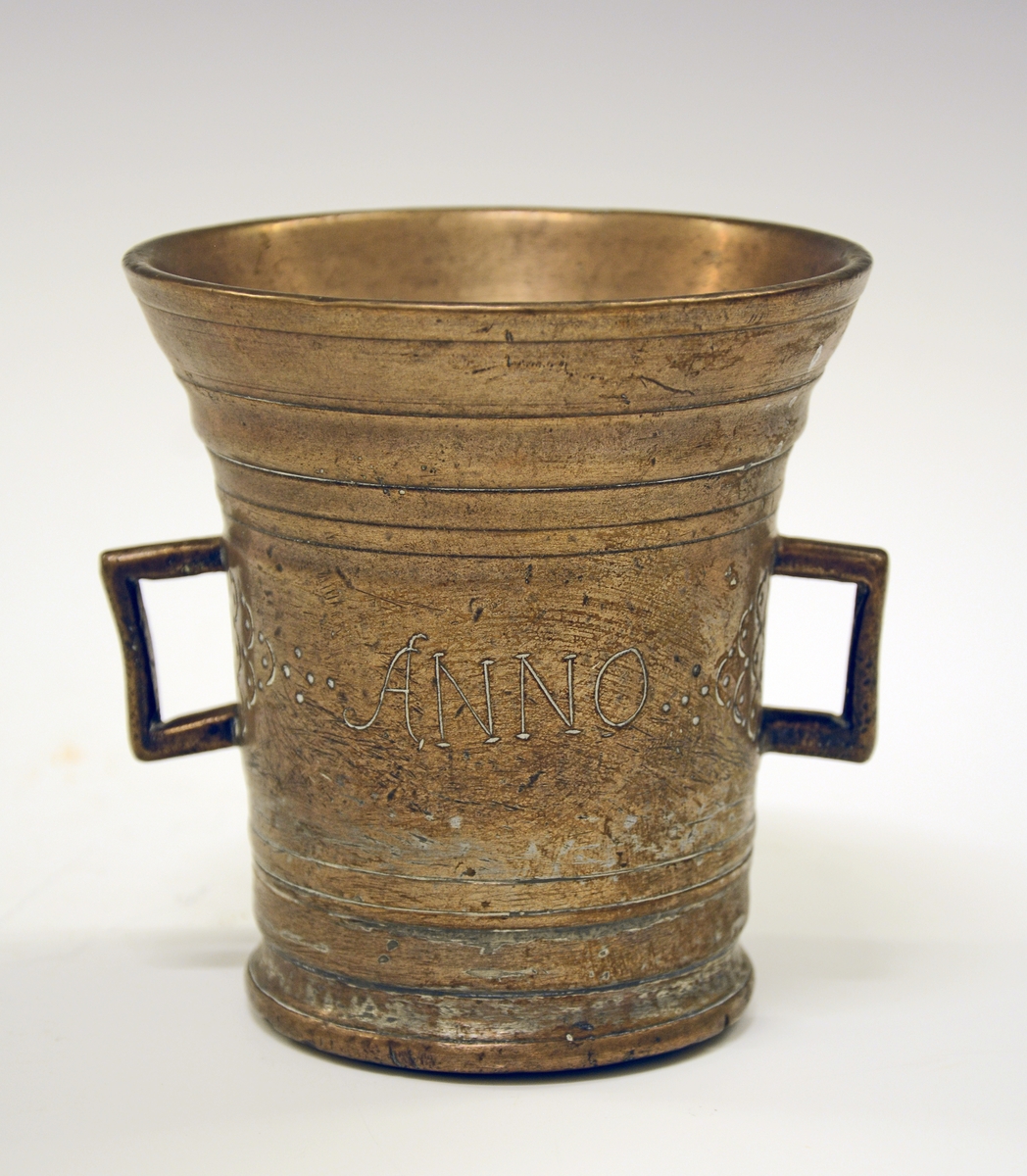 Fra protokollen:
Murte av bronse, cylindrisk, men skjæler ut uppetter; tvo henkar, støypte saman med korpus. Dreia (?) reitar rundt. Paa sidune stend i nedfeld hogst: ANNO 1688. Paa kvar side av henkane pyramide-ornament dana av halvcirklar med prikkar. Tvermaal uppe 11 cm, høgd ikr. 11 cm.