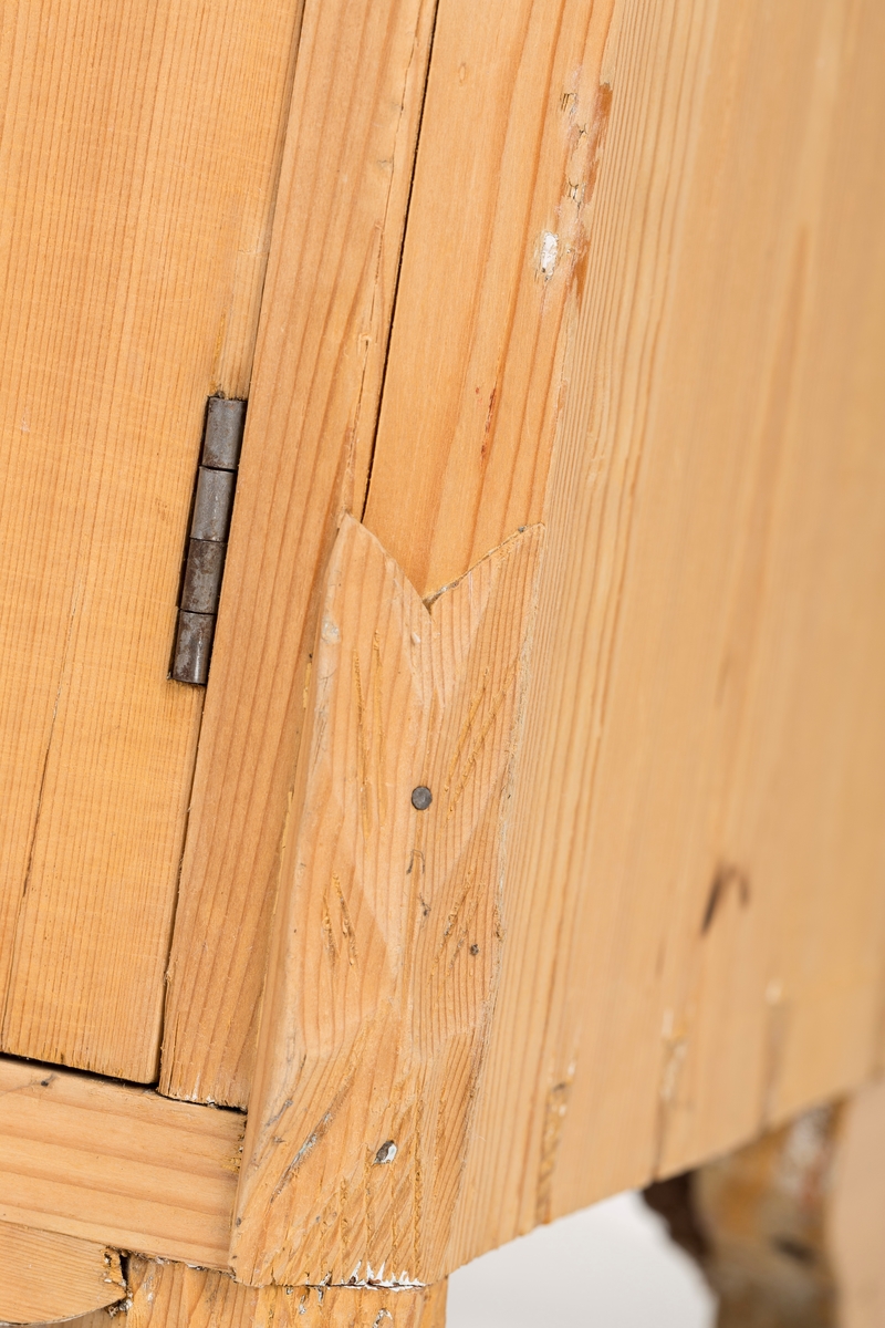 Toalettbord i ubehandlet tre. Det er rom for vaskebolle og skap under. Messingknott på døra til åpning og lukking, spor på innersiden av skapet kan tyde på at det tidligere også har vært en lås.