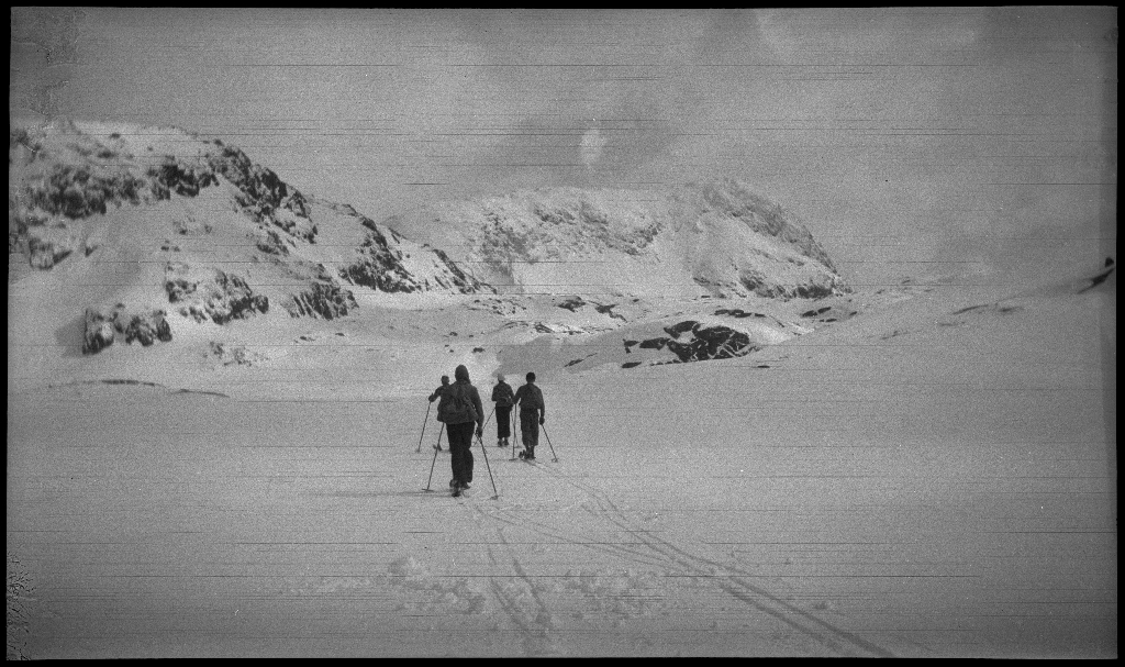 Fire unge menn på skitur påsken 1936. De har laget en bil av snø med bobleform (kanskje inspirert av Porsche Typ 1 fra 1935). Det er også bilder fra flere fjelltopper, fra skigåing og fra ei turisthytte.