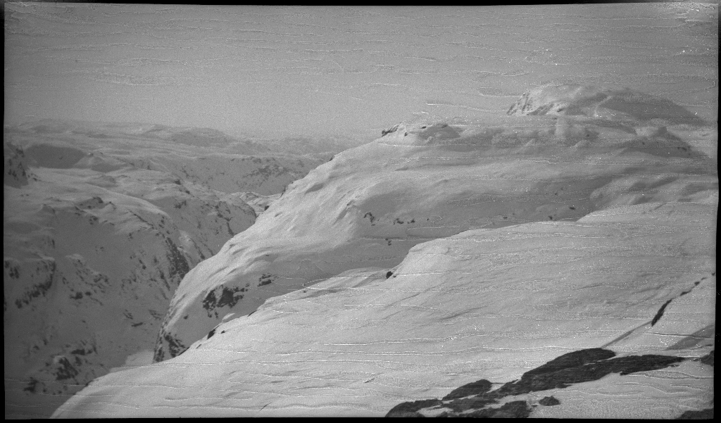 Fire unge menn på skitur fra Roalkvam til Stranddalen i Suldal. Det er bilder av hytter i fjellet, fra landskapet, lek med en hoppbakke og fra skigåing.