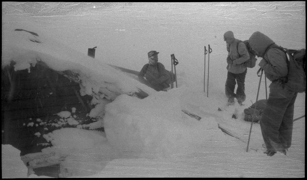 Fire unge menn på skitur fra Roalkvam til Stranddalen i Suldal. Det er bilder av hytter i fjellet, fra landskapet, lek med en hoppbakke og fra skigåing.