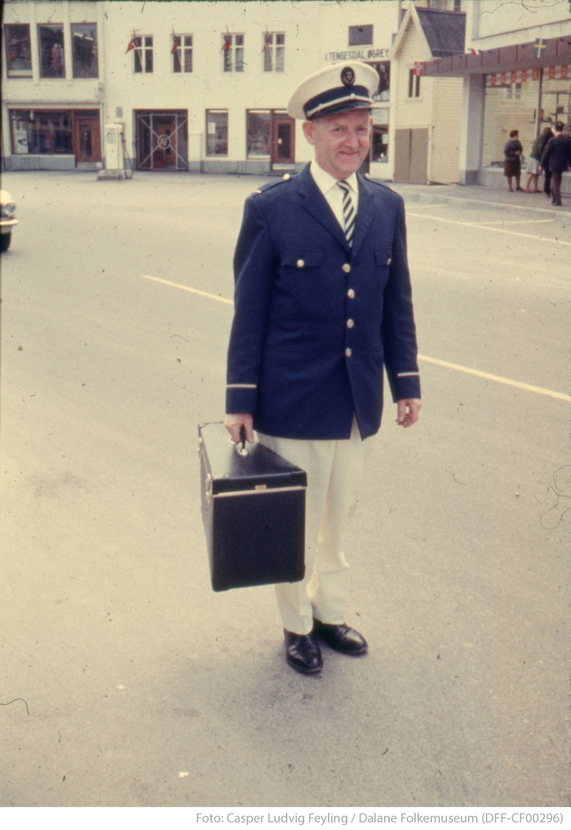 Korpsmusikant med instrumentkoffert og uniform på Nytorget i Egersund