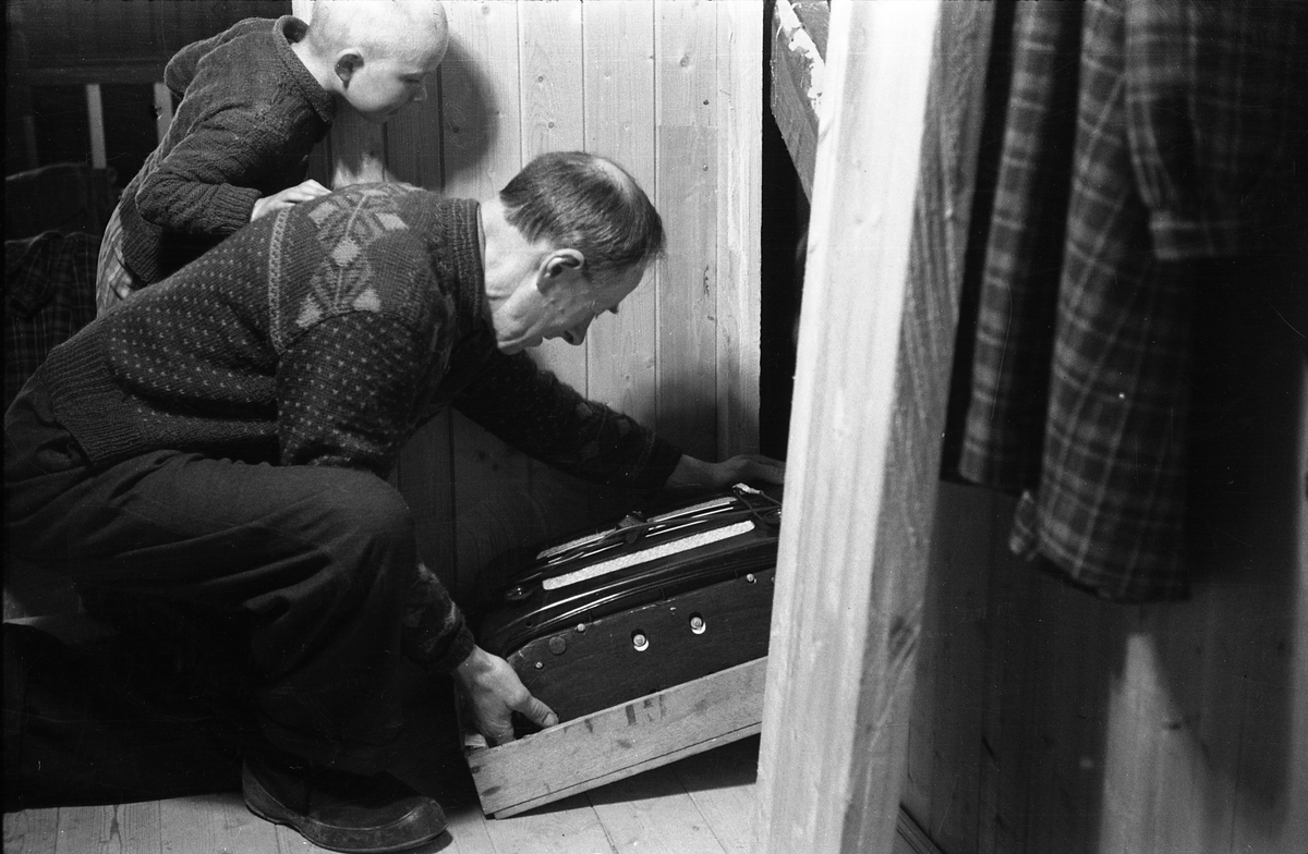 Frigjøring! Sigurd Røisli, godt hjulpet av sønnen Kjell, tar fram igjen radioen fra gjemmestedet hjemme på Odberg på Kraby, Ø.Toten.