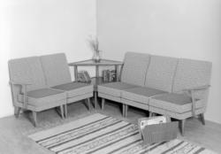 Hjørnesofa og hjørnebord samt aviskorg.