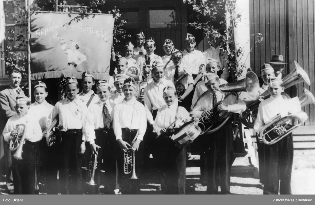 Spydeberg Guttemusikkorps i Spydeberg i 1948.

Ved fanen formann Odd Svarstad
Foran til venstre: 
Øivind Fjeld
Ragnar Fjeld
Sigmund Grini
Emil Haugland
Øistein Kristiansen
Magne Solberg
Sigurd Syvertsen

2. rekke fra venstre: 
Knut Sølvberg
Per Svarstad 
Per Ødegård
Bjarne Gulberg
Helge Vestby
Hans Thoresen (dirigent)

3. rekke: Johan Schussler, Jon Burås, Prestby.

4. rekke: Eivind Lageraaen, Arve Holmerud, Cato Haugland, Tor Fjeld, Ivar Hagen.