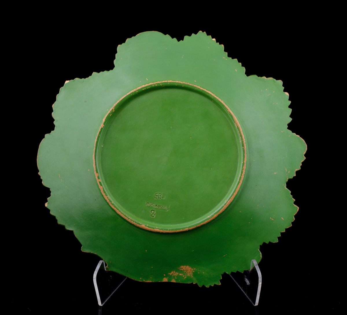 Fruktfat av keramik. 
Naturalistiskt utformat som fyra vinblad i mörkgrön glasyr.