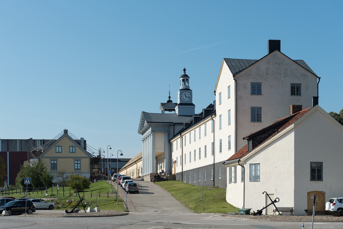 Fotodokumentation av byggnader i örlogshamnen, Karlskrona. Byggnaden närmast till höger uppfördes troligen på 1780-talet som en tillbyggnad av den dåvarande Tackelkammarbyggnaden. År 1885 revs den ursprungliga delen av Tackelkammaren ned och även det sydöstra hushörnet revs av för att det nylagda järnvägsspåret skulle kunna passera in på området. Den kvarvarande delen av byggnaden inreddes till ekipagekontor. En funktion som den hade fram till 2008.  Närmast bakom Ekipagekontoret  är Mönstersalsbyggnaden.