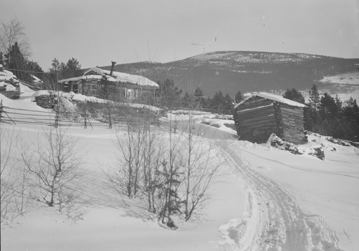 Ringebu kommune, Vinterbilde med to mindre tømmerbygninger. Snaufjell bak.