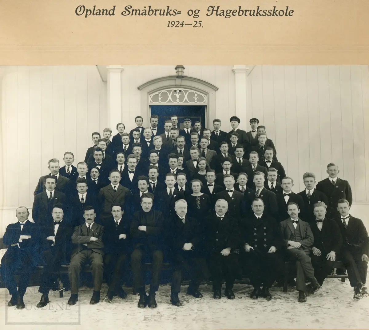 Oppland Småbruks- og Hagebruksskole (Valle) 1924-1925. Elever og lærer oppstilt på trapp foran en trebygning