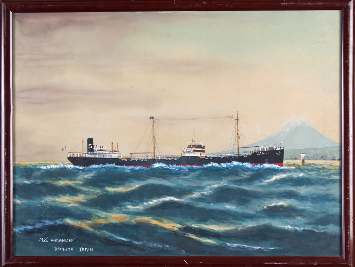 Skipsportrett av MT VARANGER under fart med norsk flagg akter. Fujifjellet og Yokohama by i bakgrunn av bildet.
