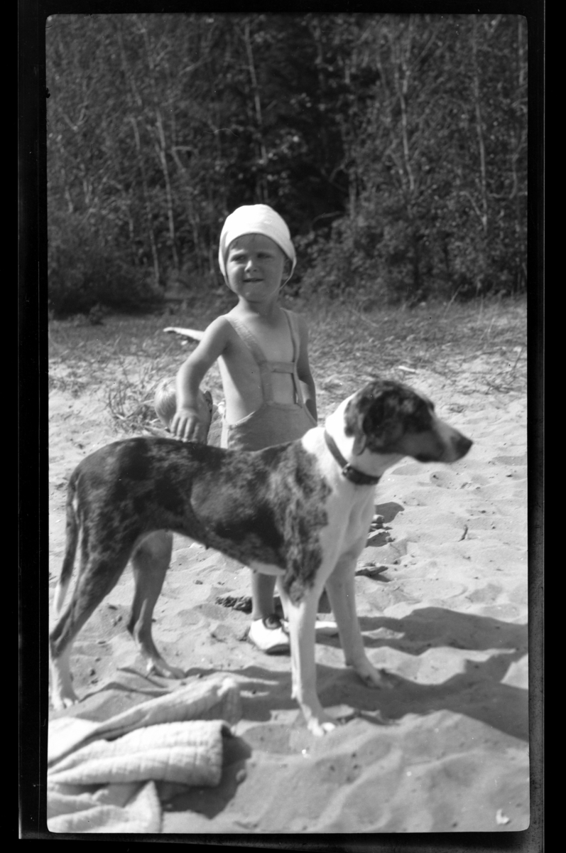Lars Peter Sundt med stor hund på en sandstrand på Ula i Vestfold. Fotografert 1932.