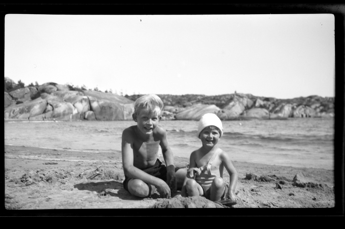 Brødrene Rolf Jr. og Lars Peter Sundt på sandstrand på Ula i Vestfold. Fotografert 1932.