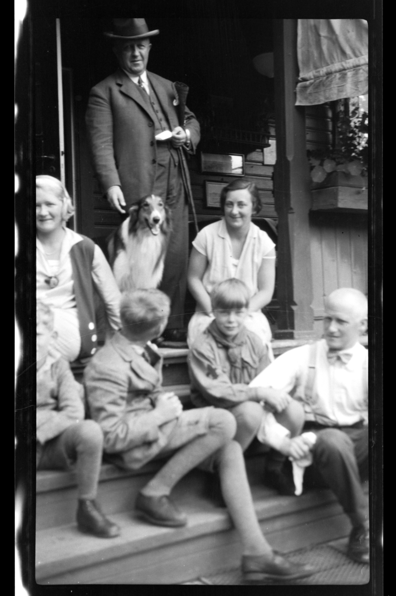 Gruppe av voksne og barn fotografert på trapp. Fra venstre Rolf Jr., Cecilie (Essemor), Finn og Julius, alle Sundt, Einar Aubert Hansen samt to kvinne og mann. Fotografert 1928.