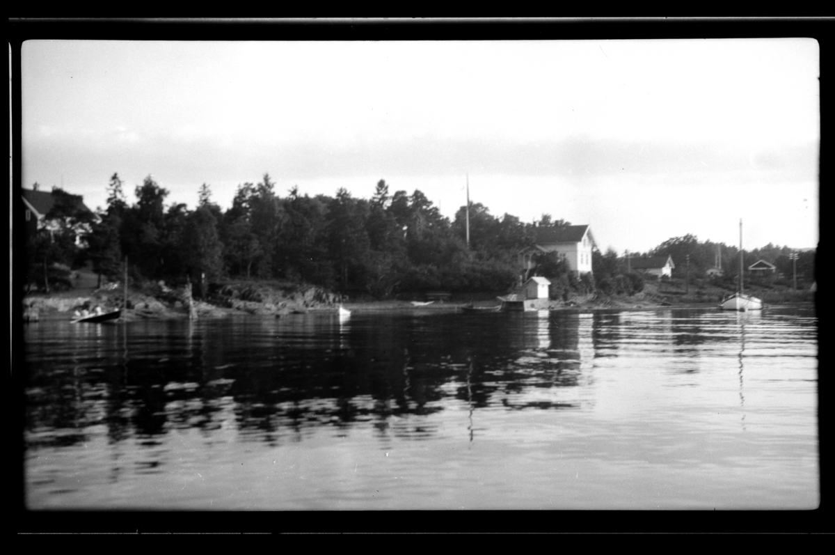 Flere hus og båter langs stranden ved ant. Konglungen. Fotografert 1930.