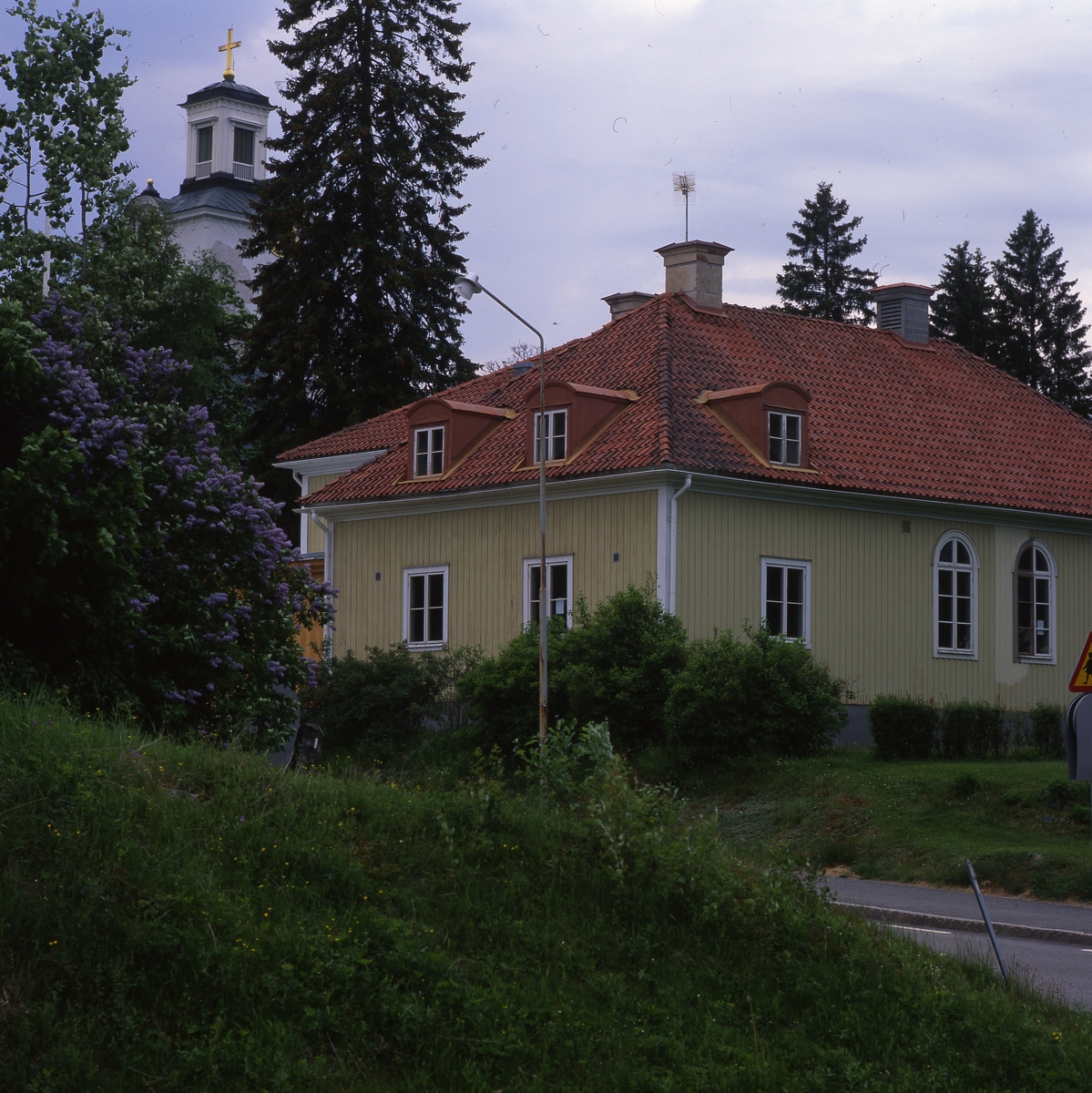 Rengsjö församlingshus med kyrkans torn i bakgrunden, juni 1999.