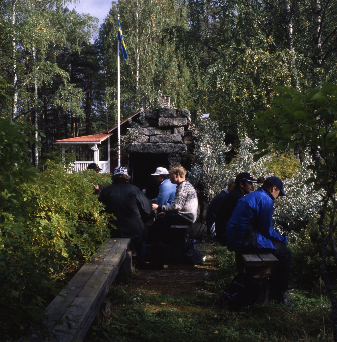Naturbruksgymnasiets elever från Ljusdal besöker Albert Vikstens torp vid Ängratörn, september 2001. Här sitter några av dem och fikar ute vid den murade eldstaden.