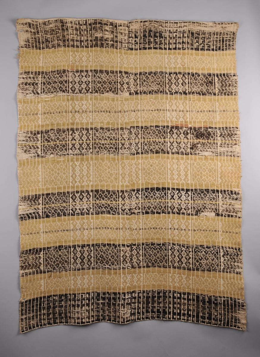 Teppet  er sauma med sauebrunt og gult totråds ullgarn på ein toskaftsvove linbotn (illuderar skilbragdteknikk).  Det er sett saman av to vevbredder som er sydd saman langs midten av teppet. Smal dobbeltbretta fald i båe kortsidene.
