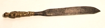 Kniv med blad av järn och skaft av mässing i form av en stående mansfigur.