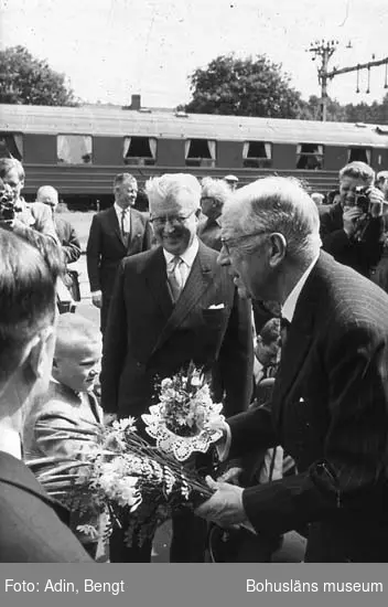 Kungainvigningen 16 juni 1964. 
Fotograf Bengt Adin, Göteborg. Regi Hans Håkansson.
Stenungsunds Järnvägsstation.
Pojke överlämnar blommor till kung Gustaf VI Adolf.