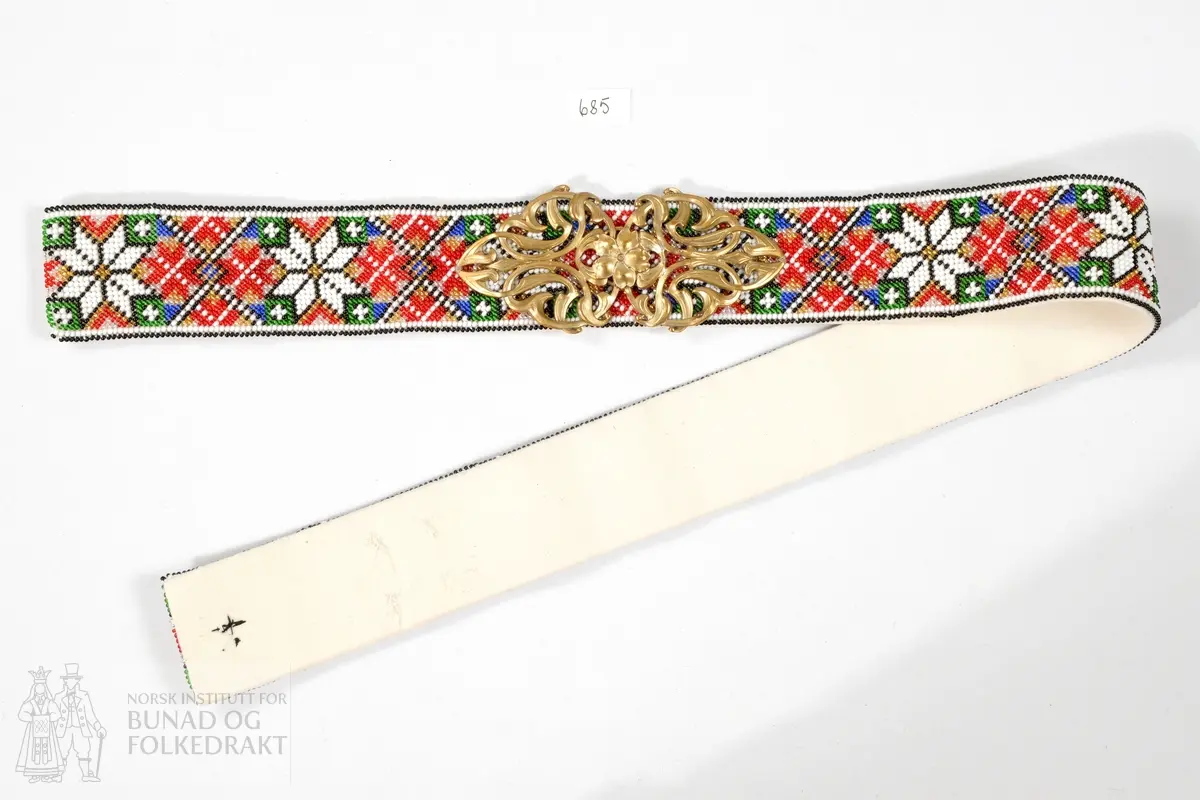 Beltespenne i messing fra omkring 1900. Nå festet til perlebrodert belte.
