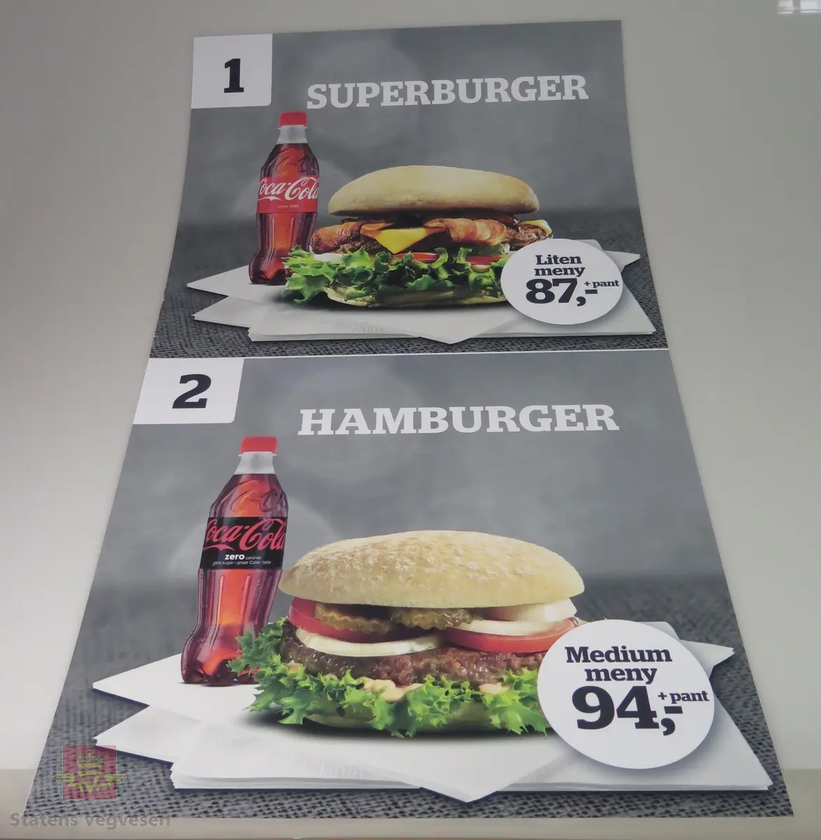 Sju ulike plakater av plast. De reklamerer for salg av pølser og hamburgere hos Statoil.