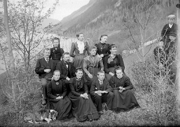 Gruppebilete av kurvmakarskulen i Lårdal 1901, med sovande harehund i forgrunnen 