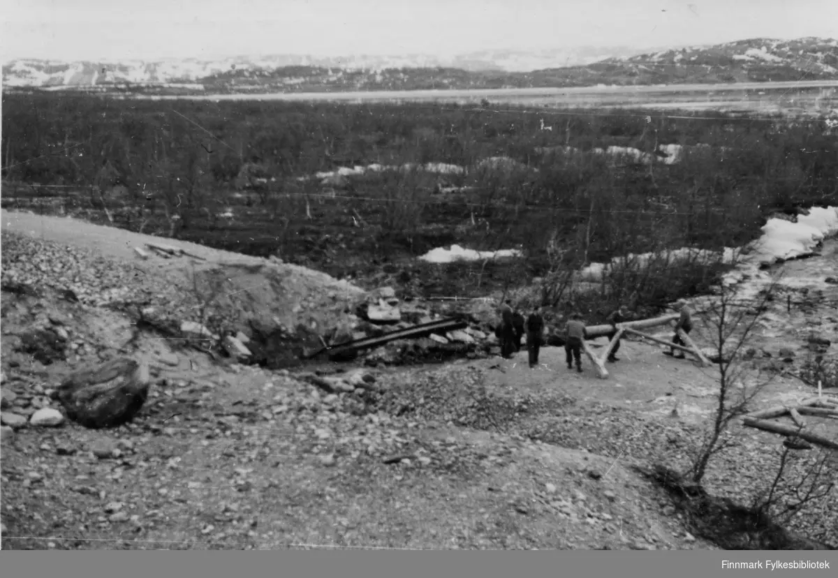 Soldater ved en elv i Finnmark. All veiforbindelse var rasert etter tyskernes tilbaketog. Ødeleggelsene var enorme. Soldatene som kom til et Finnmark uten noen form for infrastruktur, bruer var sprengt  og alt var brennt ned. 

Bildeserien "Frigjøringen av Finnmark 1944-45" viser et unikt materiale fotografert av soldater i Den Norske Brigade, 2. Bergkompani under deres oppdrag "Frigjøringen av Finnmark" som kom i stand under dekknavn "Øvelse Crofter". Fakta rundt dette bildematerialet illustrerer iflg. vår informant, George Bratli: "2.Bergkompani, tilhørende Den Norske Brigade i Skottland,  reiste fra Skottland 30. oktober 1944 med krysseren «Berwick» til Scapa Flow på Orkenøyene for å slutte seg til en større konvoi som skulle være med til Norge. Om bord på andre skip var det mange russiske krigsfanger som hadde vært på tysk side og som nå ble sendt hjem. 
2.Bergkompani forlot havn 1.november 1944 og kom til Murmansk, Sovjetunionen, 6. november 1944. 
De ble her lastet om og fraktet til Petsamo, Sovjetunionen, hvor de ankommer 11.november 1944. 
Kompaniet reiser så til Sandnes utenfor Kirkenes og blir forlagt der frem til 26.november 1944. De flytter så videre til Skipparggura. 
Den 29.november reiser deler an kompaniet til Rustefielbma og Smalfjord og noen drar opp på Ifjordfjellet. 

17. desember ankommer resten av kompaniet til Smalfjord. 30.desember blir en avdeling sendt til Hopseide og 8. januar 1945 blir noen sendt til Kunes.
Den 14. januar er kompaniet delt og ligger i Kunes, Kjæs, Børselv, Hopseide og Smalfjord.
5. februar 1945 blir 3.tropp sendt over Porsangerfjorden for å operere i Olderfjorden. Her var de i kamp og hadde tap i  Billefjord og Sortvik.
8.mars 1945 kom noen til Renøy og 12. mars kom første del av kompaniet til Brennelv.
7.mai begynte kompaniet å bygge ny kai i Hambukt.
19. mai ble de som hadde falt begravd i Lakselv.
8. juni ble kompaniet flyttet fra Brennelv til Tromsø for så å bli sendt videre til Mo I Rana 16.juni."

Nasjonalbiblioteket har et hefte fra 1983 skrevet av Krigsinvalideforbundet, med intervjuer med soldater og deres opplevelser: 
https://www.nb.no/items/5d58d366b390666f671f57078519c2c7?page=0&searchText=Det%20glemte%20kompani%20-%202.%20Bergkompani%20og%20frigj%C3%B8ringen%20av%20Finnmark

https://www.arkivverket.no/utforsk-arkivene/andre-verdenskrig/befolkede-jordhuler-kjokken-i-det-fri-og-midlertidige-begravelser-privat-bildesamling-etter-soldat-i-2.bergkompani
