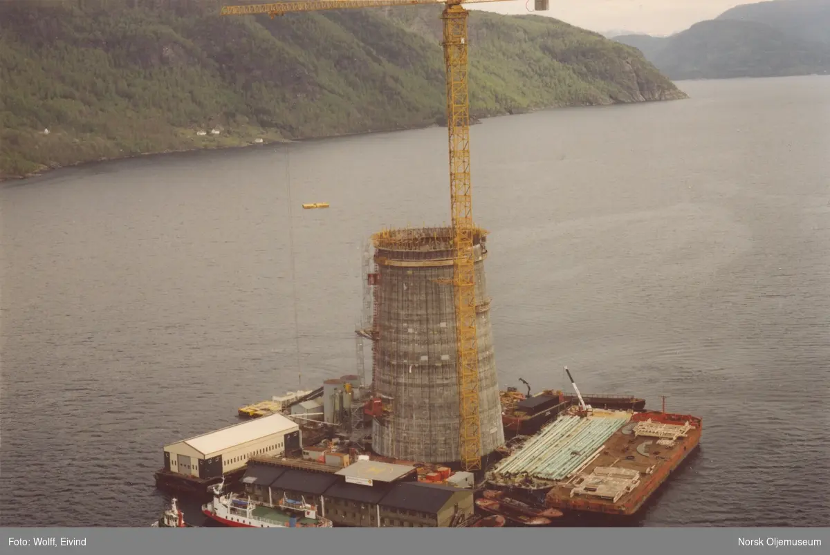 Betonskjørtet er nå helt under vann.Det brukes glidestøping for å støpe den massive søylen som skal holde draugendekket høyt over vann.

Mai, 1992.