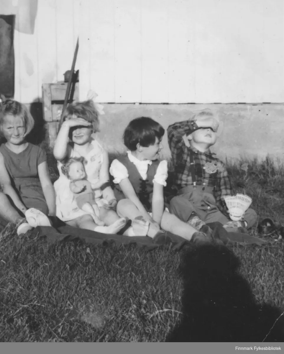 Barn som leker sammen ute på gressplen. Familiealbum tilhørende familien Klemetsen. Utlånt av Trygve Klemetsen. Periode: 1930-1960.