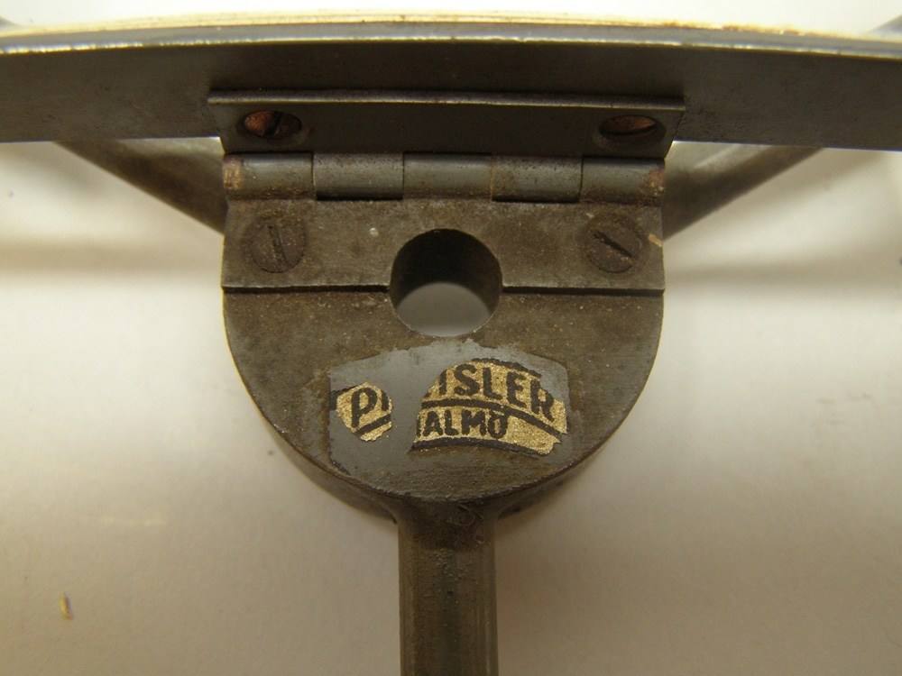Instrument av mässing målad i mörk brunblå kulör som tillhört ångfärjan Starke. Mitt på instrumentet är ett förstoringsglas fastsatt med ett gångjärn av mässing.