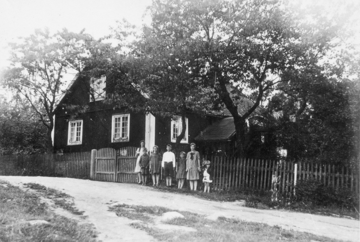 Framför verkmästarbostaden vid Ohs bruk står syskonen Andersson. Från vänster Greta, David, Ingrid, Torsten, Judit, Signi och Margit.