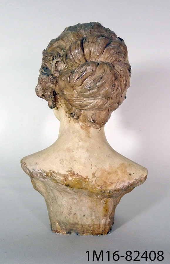 Porträttbyst av kvinna (M me D. Paris) med uppsatt hår. Kvinnan tittar lite snett uppåt vänster.
