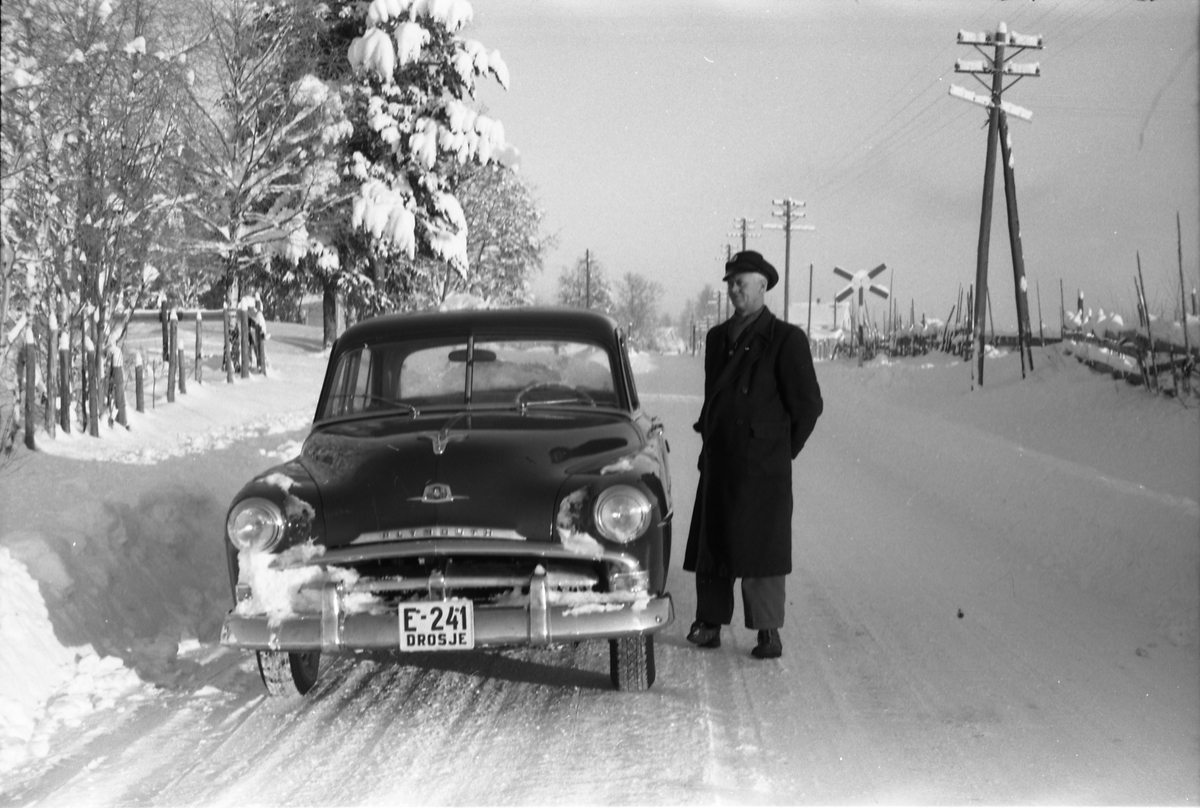E-241, drosje på Lena i Østre Toten. Ved sida av bilen står eier og sjåfør Mauritzs Enger. Tre bilder som ser ut til å være tatt rett vest for der jernbanen krysset vegen mellom Lena og Kolbu, det som ble kalt Schjøll-overgangen. Bilen er en Plymouth 1951-52.