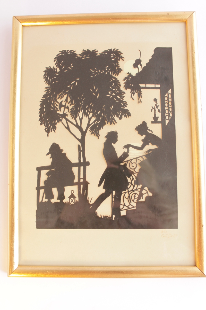 Svart silhuettklipp på vitt papper bakom glas med guldfärgad ram. Motivet föreställer en ung man som står nedanför en trappa till ett hus och håller en ung kvinna i handen. Kvinnan är påväg ut på trappan för att möta den unge mannen. Hon ser ut att vara klädd i klänning från mitten av 1800-talet. Till vänster i bild sitter en gammal man på en bänk böjd över sin käpp och med en skärmmössa på huvudet. Vid hans fötter står en lykta. Bänken står under ett träd. På taket till huset står en katt och skjuter rygg. En vit fullmåne syns bakom katten och lite månglitter skymtar bakom den unge mannens och kvinnans händer.