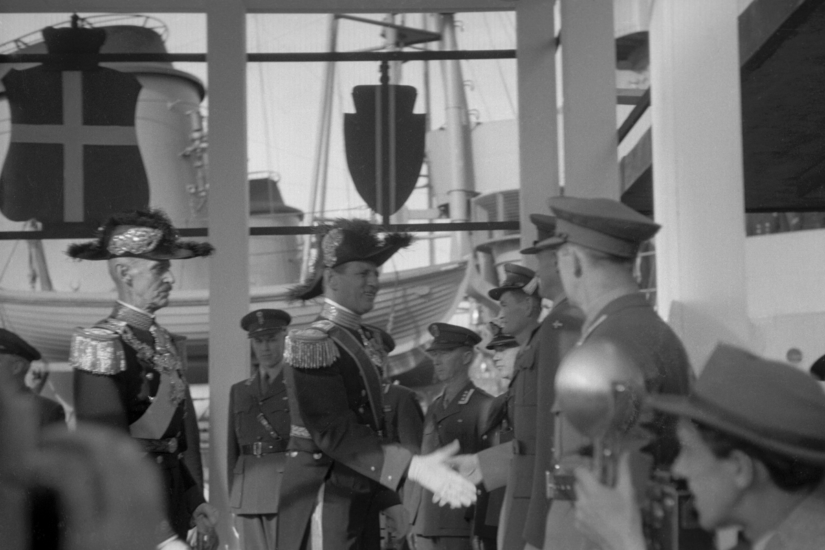 Kong Frederik og Dronning Ingrid på offisielt besøk i Norge.  Her hilser kong Frederik på offiserer fra forskjellige våpengrener. Kong Haakon og Kong Frederik bærer begge snutehatt.