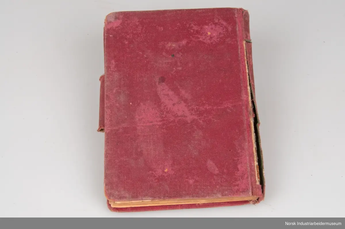 Liten rød notisbok og almanakk med harde bokrygger og en gang utsmykket med gullskrift. Serieprodusert publikasjon som sannsynligvis var i bruk fra 1921. Forholdsvis slitt rygg. Sidene 2 tom 4 er løsrevne fra bokryggen.