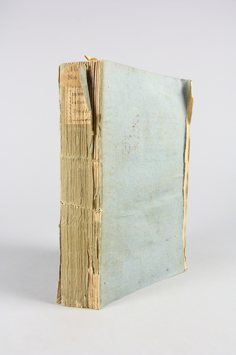 Bok, pappband, "Mémoires de Jean-Sylvain Bailly", del 2, tryckt 1804 i Paris. Pärmar av gråblått papper, blekt rygg med tryckta etiketter. Klistrade sidor ur annan bok på pärmarnas insidor. Skuret snitt.