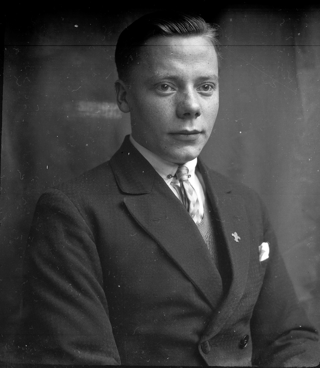 Porträtt av en ung man med slips, skjorta, väst och kavaj. I fotografens egna anteckningar står det "Åke Thorsell". Tolkat som Åke Gustaf Kristian Thorsell (f. 1911).