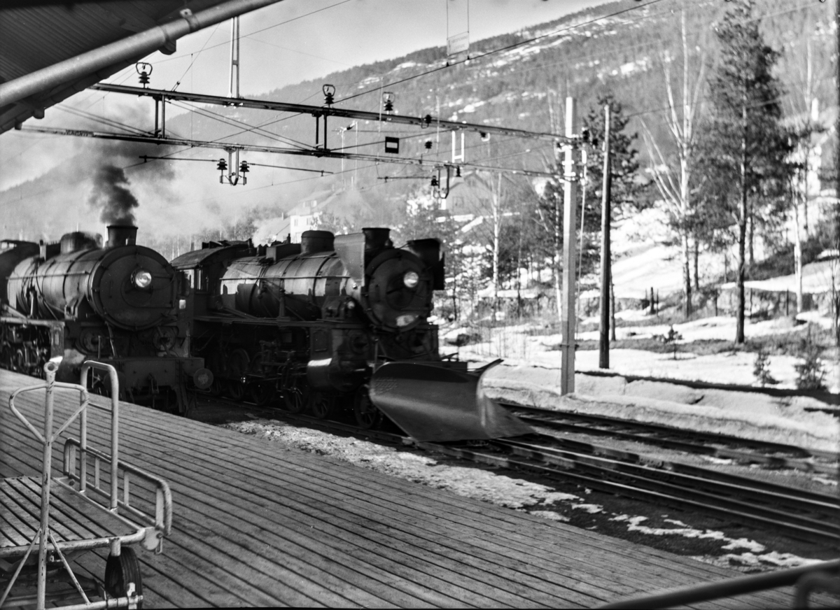 Damplokomotiv type 31b nr. 418 (t.h.) i ekstratog (påsketog) nr. 7608. Til venstre damplokomotiv type 31b nr. 449 i godstog 5532 på Nesbyen stasjon.