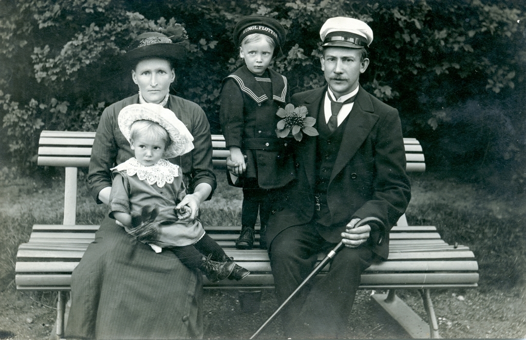 Familjen Träff sitter på en parkbänk. Mariana, Helge, Agnes och Oskar.